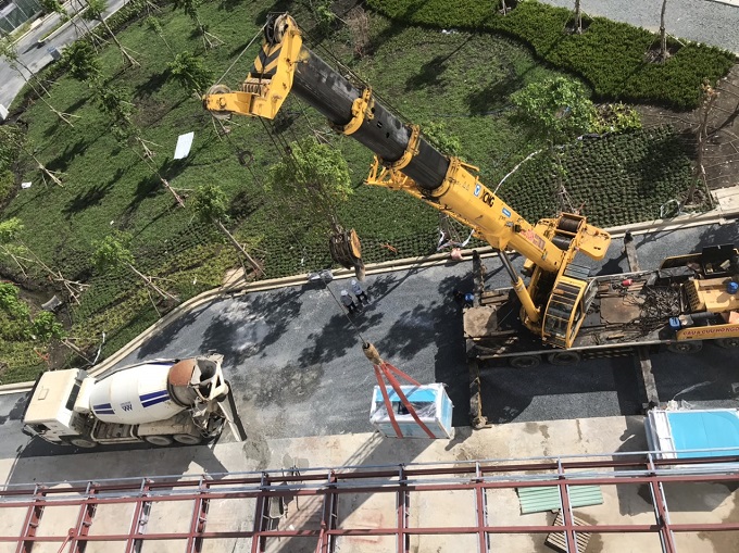 Xe cẩu đang vận chuyển máy móc từ dưới đất lên tầng cao tại Bệnh Viện Nhi Đồng